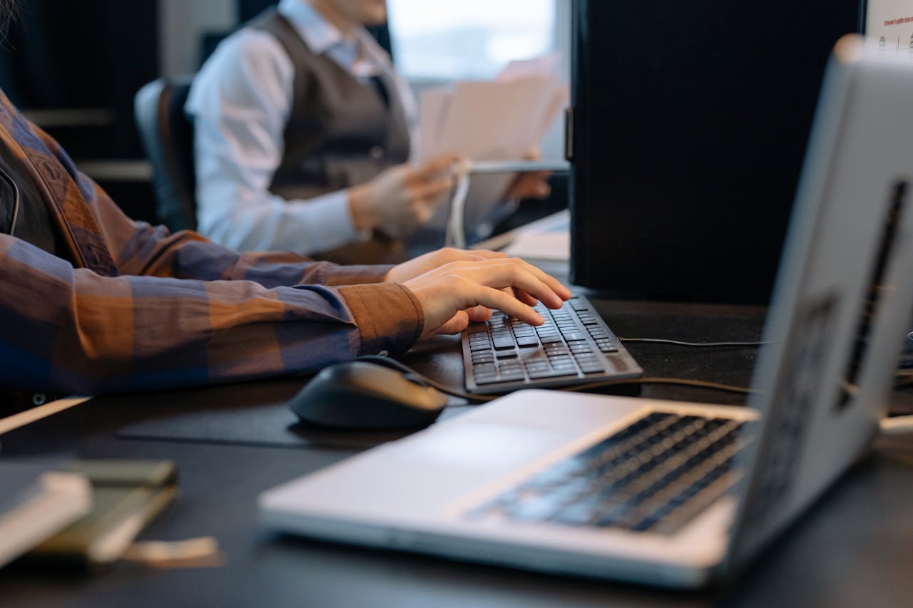 About Close-up of office workers engaged in a tech project at a modern workplace.
