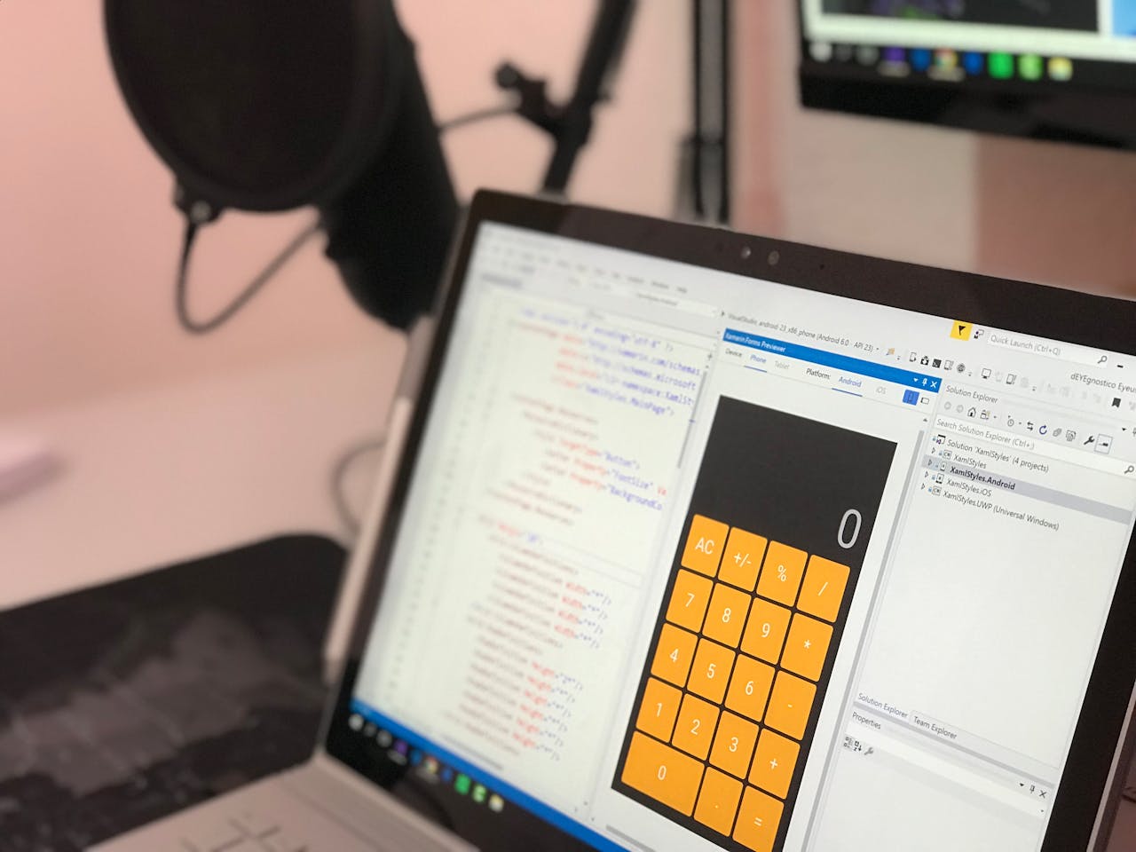 Home Close-up of a laptop displaying code and a calculator app in a modern workspace.